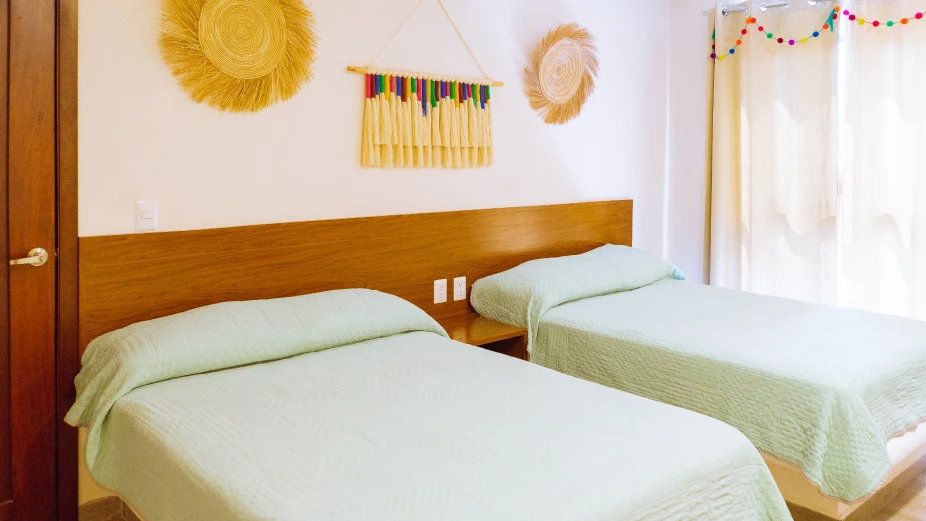 habitacion-con-dos-camas-y-edredon-verde