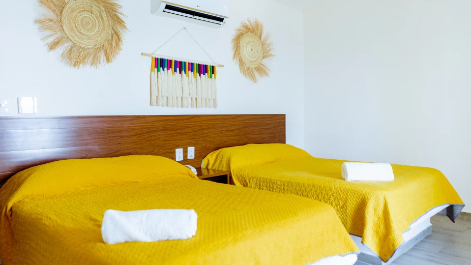 habitacion-con-dos-camas-tendidas-con-edredones-amarillos
